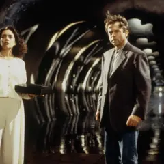 Uomo e donna in un tunnel futuristico. Lei tiene una scatola nera, forse il seme della follia, il cui significato è ancora ignoto.