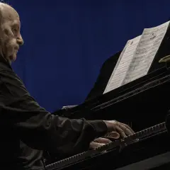 Un anziano pianista, con i capelli lunghi e grigi, suona un pianoforte a coda. Le sue mani esperte danzano sui tasti, seguendo uno spartito. Le recensioni per il pianista sono unanimi: un vero maestro.