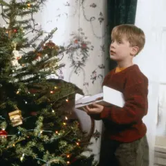 Kevin, protagonista di "Mamma, ho perso l'aereo", guarda sorpreso un intruso fuori dalla finestra, vicino all'albero di Natale.