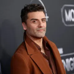 Oscar Isaac, l'attore di Moon Knight, posa con un cappotto marrone.