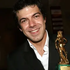 Favino giovane sorride con un premio David di Donatello dorato.