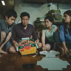 La famiglia Kim assembla scatole per pizza, una scena chiave nella **recensione** di "Parasite".
