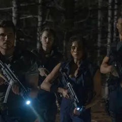 Quattro personaggi armati e con torce si muovono cauti nel bosco, pronti ad affrontare pericoli. Resident Evil: Welcome to Raccoon City recensioni.