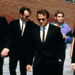 Sei uomini in abito nero camminano in gruppo, un cast cinematografico iconico.
