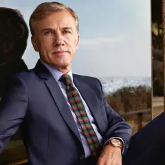 Christoph Waltz, con un completo blu e cravatta a quadri, riflette sul suo percorso costellato di premi vinti.