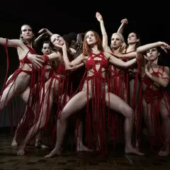 Danzatrici in abiti rossi intrecciati, un'immagine evocativa per la recensione di Suspiria 2018.