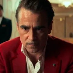Colin Farrell in un film Netflix, con un'espressione intensa, indossa una giacca rossa.
