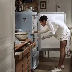 Ragazzo in pigiama cerca qualcosa nel frigo, forse il finale dei funny games.