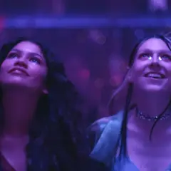 Due ragazze, immerse in luci viola, vivono un momento di pura **euforia 2**.