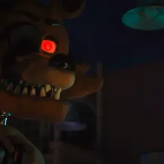 Occhio rosso minaccioso per la recensione di Five Nights at Freddy's. L'animatronic Foxy si avvicina nell'ombra.