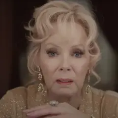 Jean Smart, parte del cast di Babylon, con un'espressione intensa e gioielli scintillanti.