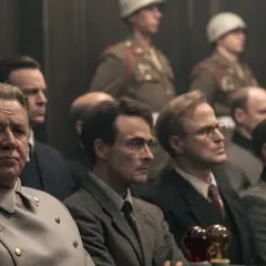 La recensione del film "Il processo ai nazisti" a Norimberga: uomini in uniforme e abiti civili siedono in un'aula di tribunale.