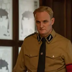 L'uomo dal cuore di ferro, in uniforme, con sguardo severo. Le recensioni lo descrivono come un personaggio complesso.
