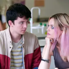 Una recensione di Sex Education: Otis e Maeve si guardano intensamente, mentre un'altra ragazza è sfocata sullo sfondo.