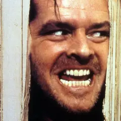 Occhi bianchi e un sorriso folle, un volto che spunta da una porta in un momento di terrore shining congelato.