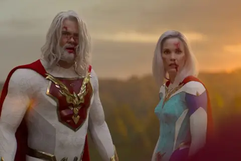 Il cast di Jupiter's Legacy, con volti feriti, guarda verso l'orizzonte al tramonto.