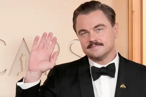 Leonardo DiCaprio, con baffi e smoking, saluta. Quanti Oscar ha vinto Leonardo DiCaprio? Uno, per "The Revenant".