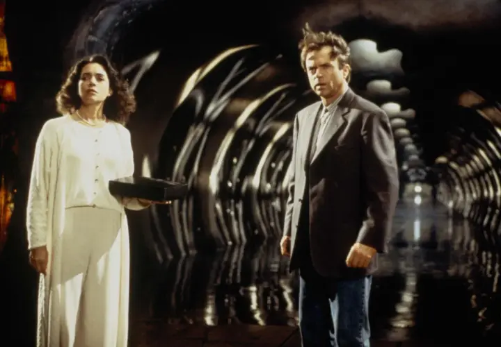 Uomo e donna in un tunnel futuristico. Lei tiene una scatola nera, forse il seme della follia, il cui significato è ancora ignoto.