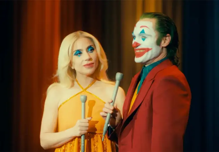 Joker e Harley Quinn, con il trucco da clown, cantano sul palco. Una scena iconica del finale di Joker.