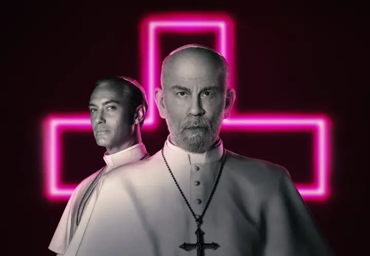 Due papi, uno giovane e uno anziano, sullo sfondo di una croce al neon rosa. La recensione del nuovo papa è intensa.