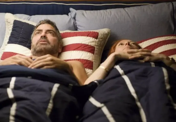 Il cast di Burn After Reading, a prova di spia, in un letto. George Clooney e Tilda Swinton sembrano preoccupati.