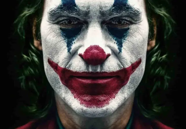 Il volto truccato da clown, con un sorriso rosso e lacrime blu, incarna il vero joker significato: la follia che nasce dal dolore.