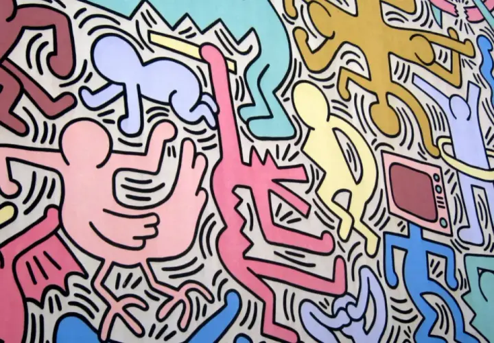 Un'esplosione di figure stilizzate e colorate, un'iconica opera di Keith Haring che celebra la vita e il movimento.