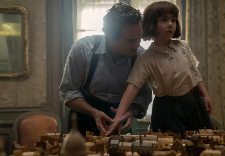 Un uomo e una bambina osservano un plastico di città. Un momento che evoca "tutta la luce che non vediamo recensioni".