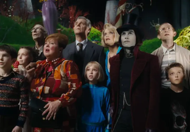 A group of children and adults, including Willy Wonka, look up in awe in a fantastical candy landscape.