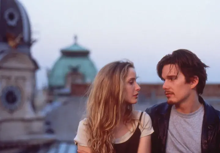 Jesse e Celine, protagonisti della trilogia before, si guardano intensamente sui tetti di Vienna.