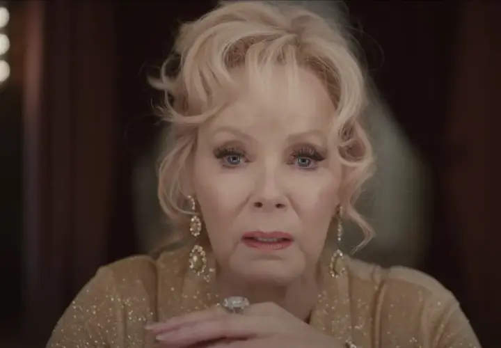 Jean Smart, parte del cast di Babylon, con un'espressione intensa e gioielli scintillanti.