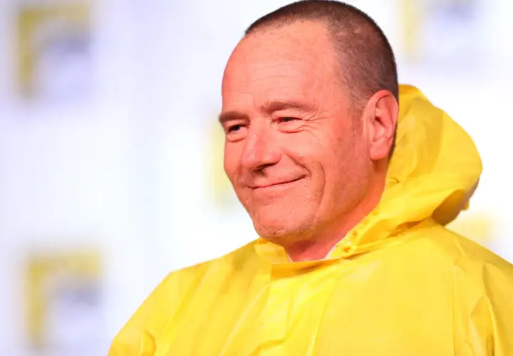 Bryan Cranston sorride con la sua iconica tuta gialla, ricordando le citazioni di Breaking Bad.