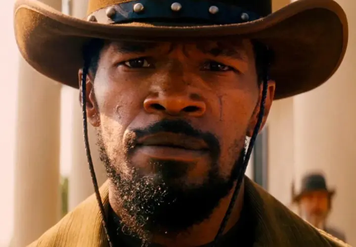 Primo piano di Django, con cappello da cowboy e barba. Il suo sguardo intenso evoca il significato di libertà e vendetta in Django Unchained.