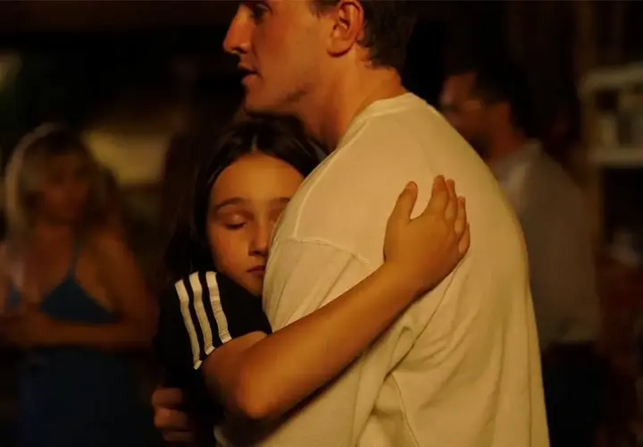 Un abbraccio intenso, una bambina si stringe a un uomo. Una scena che fa pensare a un momento di conforto, quasi una spiegazione dopo il sole.