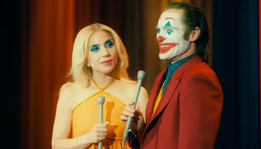 Joker e Harley Quinn, con il trucco da clown, cantano sul palco. Una scena iconica del finale di Joker.