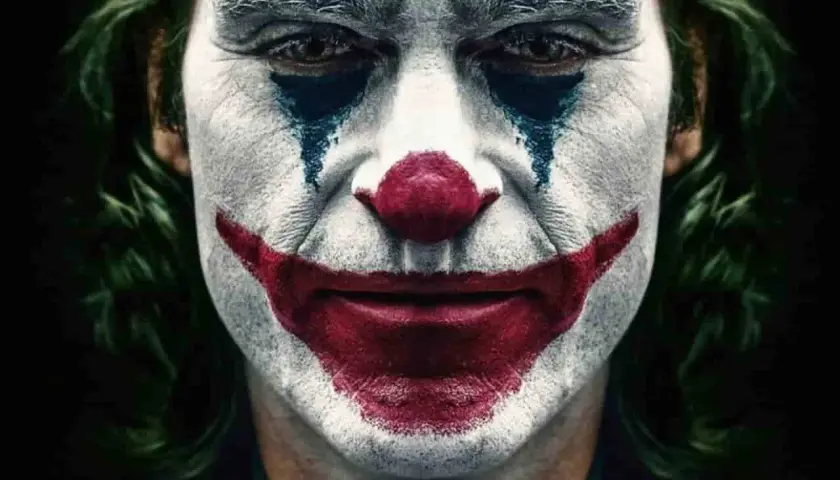 Il volto truccato da clown, con un sorriso rosso e lacrime blu, incarna il vero joker significato: la follia che nasce dal dolore.