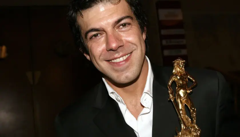 Favino giovane sorride con un premio David di Donatello dorato.