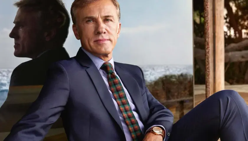 Christoph Waltz, con un completo blu e cravatta a quadri, riflette sul suo percorso costellato di premi vinti.