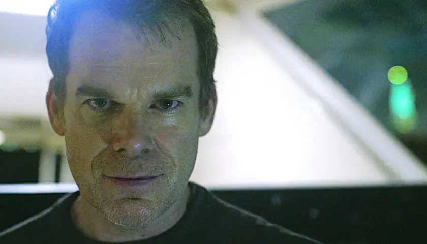 Primo piano di Dexter, con uno sguardo intenso. Le recensioni su Dexter lo descrivono come un personaggio complesso.