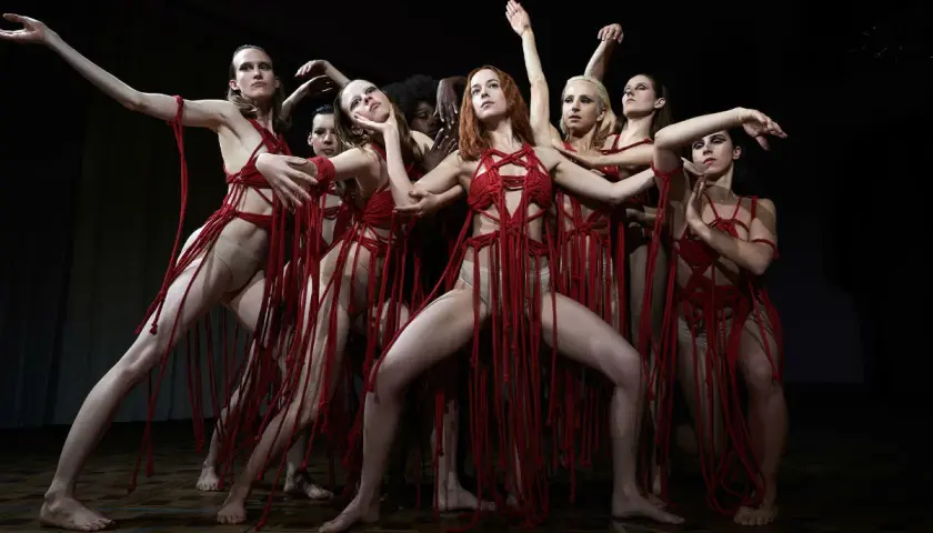Danzatrici in abiti rossi intrecciati, un'immagine evocativa per la recensione di Suspiria 2018.