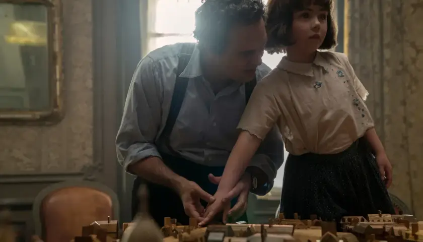 Un uomo e una bambina osservano un plastico di città. Un momento che evoca "tutta la luce che non vediamo recensioni".