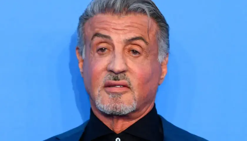 Sylvester Stallone, l'iconico Rocky Balboa oggi, con capelli grigi e barba corta, guarda intensamente.