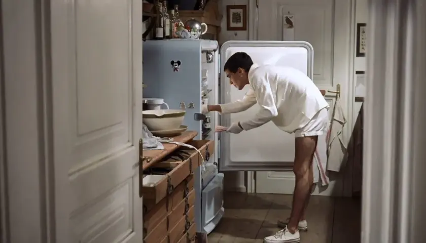 Ragazzo in pigiama cerca qualcosa nel frigo, forse il finale dei funny games.