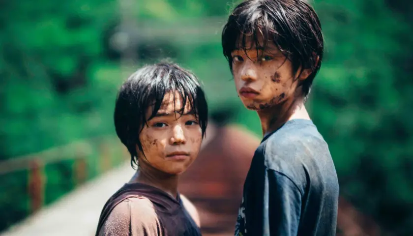 Due ragazzini sporchi di terra, con sguardi intensi, sembrano usciti da un film di mostri. Le loro espressioni suggeriscono storie che meritano recensioni.