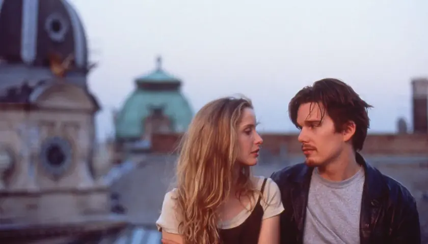 Jesse e Celine, protagonisti della trilogia before, si guardano intensamente sui tetti di Vienna.