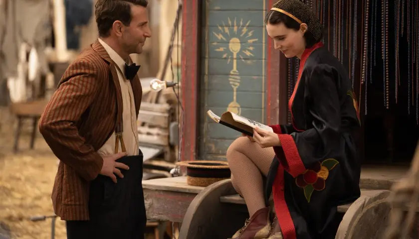 Uomo con giacca a righe e donna con vestito nero leggono un libro, forse la spiegazione de la fiera delle illusioni.