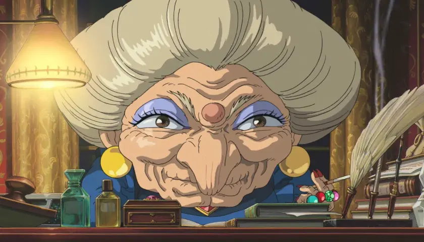 La strega Yubaba, figura chiave de "La città incantata", con il suo sguardo penetrante e la sua scrivania piena di oggetti misteriosi.