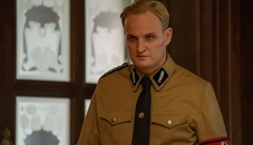 L'uomo dal cuore di ferro, in uniforme, con sguardo severo. Le recensioni lo descrivono come un personaggio complesso.