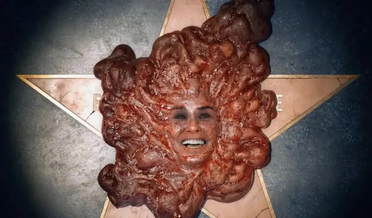 Volto umano emergente da una massa carnosa e pulsante, un'immagine disturbante tipica del **film body horror**.