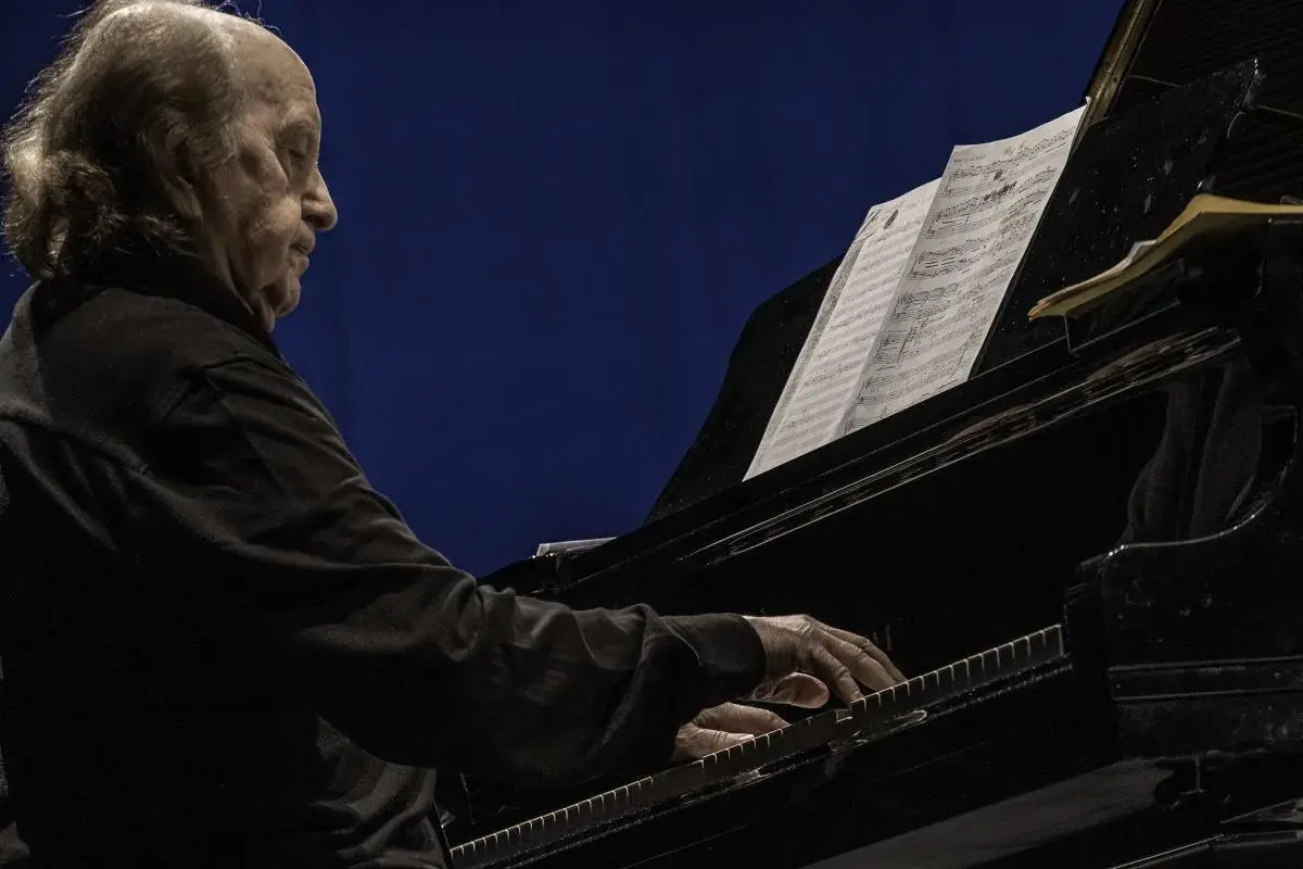 Un anziano pianista, con i capelli lunghi e grigi, suona un pianoforte a coda. Le sue mani esperte danzano sui tasti, seguendo uno spartito. Le recensioni per il pianista sono unanimi: un vero maestro.